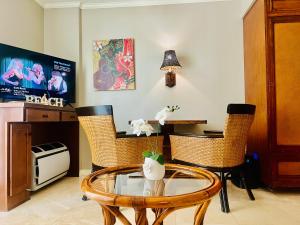 檀香山的住宿－Aloha Gem Studio - 2 bed with high speed WIFI - Luana Waikiki Hotel & Suite 917, 2045 Kalakaua Avenue HI 96815，客厅配有玻璃桌和椅子