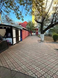a brick sidewalk with a tree and a building at Crang Luxury View in Buzău