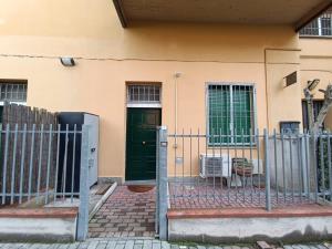 una recinzione di fronte a una casa con una porta verde di La perla a Bologna