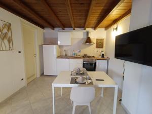 波隆那的住宿－La perla，厨房配有白色的桌子和电视。