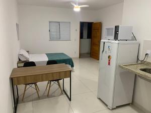Loft LISBOA para Casais, em Iguaba Grande, 3 Pessoas, 150 metros da praia في إيغوابا غراندي: غرفة فيها ثلاجة وطاولة وسرير