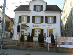 una casa blanca con una valla delante en Le MONOT Residence en Basilea