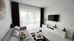 - un salon avec un canapé et une grande fenêtre dans l'établissement ONE Apartment Militari, à Bucarest