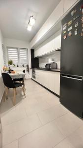 uma cozinha com uma mesa e um frigorífico preto em ONE Apartment Militari em Bucareste