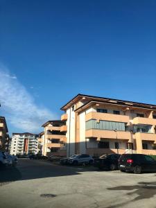 a parking lot with cars parked in front of a building at Garsonieră- Bulevard Dem Rădulescu in Râmnicu Vâlcea