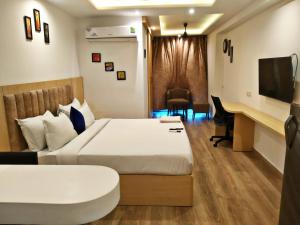 Cette chambre comprend un lit et un bureau. dans l'établissement The Grand Anukampa Inn Pink City, à Jaipur