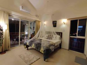 a bedroom with a bed with a mosquito net at ‘The Mountain Majesty’: cozy 1 bhk apartment in Karjat +19 photos