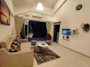 a living room with a couch and a table at ‘The Mountain Majesty’: cozy 1 bhk apartment in Karjat