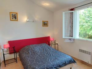 Village de gîtes La Fontinelle في Bessas: غرفة نوم بسرير احمر ونافذة