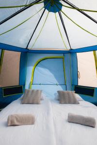 uma cama grande numa tenda com duas almofadas em Luxury tent - Villmarkseventyret em Håtvet