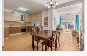 uma cozinha e sala de jantar com uma mesa de madeira e cadeiras em Casa Adriana em Murchas