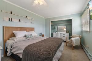 ein Schlafzimmer mit einem Bett, einem Stuhl und einer Kommode in der Unterkunft Bayside cottage steps from the harbor in Rock Hall