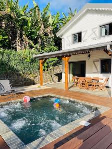 um quintal com uma piscina e uma casa em Austral House-chalet sud sauvage em Saint-Joseph