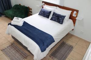 a bed with blue and white sheets and pillows at Sunny Stay in Groblersdal