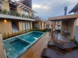 a swimming pool in the backyard of a house at Pousada Kirana in Praia do Rosa