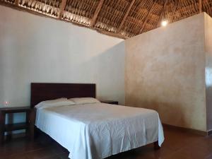 a bedroom with a white bed in a room at Hotel Cabañas Maalokin in Cobá