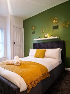 a bedroom with a large bed with green walls at Modern and spacious apartment! in Liverpool