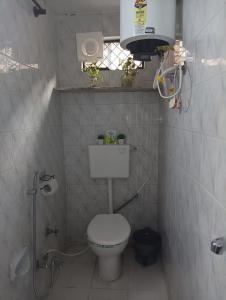 a small bathroom with a toilet and a shower at Vanita home stay in Udaipur