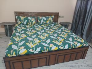 a bed with a green and yellow floral bedspread at Vanita home stay in Udaipur