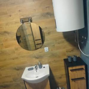 een badkamer met een wastafel en een spiegel bij Domek całoroczny in Buda Ruska