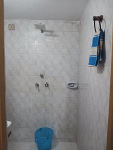 Vanita home stay في أودايبور: حمام مع دش ومرحاض أزرق