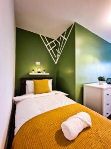 a bedroom with a bed with a green wall at Modern and spacious apartment! in Liverpool
