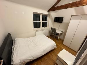 a small bedroom with a bed and a desk at 3 BEDROOMS WITH 2 PARKING SPACES in Brighton & Hove