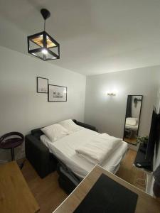 a bedroom with a bed and a table and a mirror at Appartement cosy 10 min stade de France in Saint-Denis