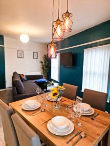 a dining room table with plates and glasses on it at Modern and spacious apartment! in Liverpool