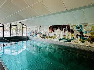 an empty swimming pool with a painting on the wall at See-Apartment AURA am Fuße der Gerlitzen Alpe und Ufer des Ossiacher Sees - mit privatem Seezugang & Hallenbad in Steindorf am Ossiacher See