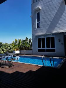 a pool with a table and chairs next to a house at NVD12A #notrevilladagonvd for 10pax in Bandung
