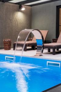 a pool with a water fountain in a room at Jazz Hotel in Tbilisi City