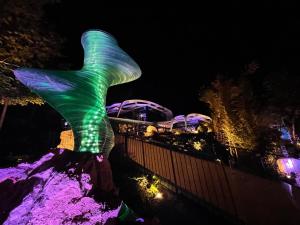 Eine Statue einer Meerjungfrau leuchtet nachts in der Unterkunft Poets Garden Villa in Budapest