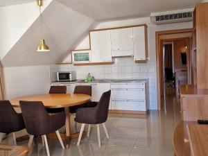 a kitchen with a wooden table and a table and chairs at Aparthotel Gaja in Bled