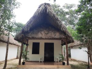 a small house with a thatched roof at Hotel Cabañas Maalokin in Cobá