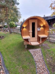 a circular wooden sauna with a bench in a yard at Ferienhaus BIBERCHALET und BIBERBAU in Bad Lauterberg