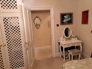 een badkamer met een wastafel en een spiegel naast een deur bij Lloyds Penthouse in Tavistock