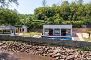 a house with a swimming pool next to a river at Villa Diamond One in Banja Luka