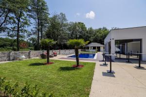 a yard with two palm trees and a pool at Villa Diamond One in Banja Luka