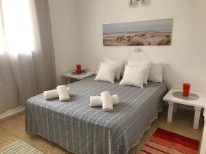 1 dormitorio con 1 cama con toallas en APT CalmaCabana a 50m dal mare, en Es Pujols