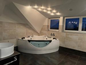 ein großes Bad mit einer Badewanne und einem Waschbecken in der Unterkunft 205 qm "Traumtor" mit Sauna, Whirlpool, Kamin und 3 Terrassen mit Blick in die Böhmisch Sächsische Schweiz in Dresden