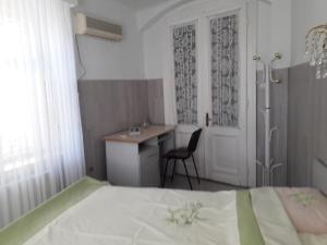 1 dormitorio con cama, escritorio y mesa en Casa Mari en Sibiu