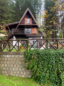 una cabaña de madera en el bosque con una valla en Chalet Natura Sport&Relax, en Cavaliere
