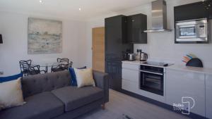 a living room with a couch and a kitchen at The Stables, Chester - Luxury Apartments by PolkaStays in Chester