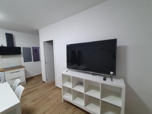 una sala de estar con TV de pantalla plana en un armario blanco en Casita isabelita, en Valle de Santa Inés