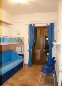 a bedroom with a bunk bed with blue curtains and a chair at Hiera in Acquacalda