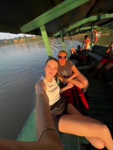 deux femmes assises sur un bateau sur l'eau dans l'établissement Tronco Tambopata Adventure, à Puerto Maldonado