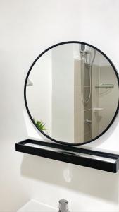 a round mirror on a shelf in a bathroom at L. Casa • Tagaytay Staycation in Tagaytay