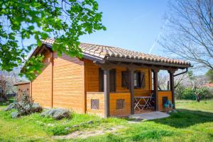 a small wooden cabin in a grassy field at Apartamentos Rurales El Rincón del Jerte in Rebollar