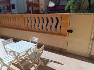 a table and two chairs next to a fence at suite4relax - near poetto beach in Quartu SantʼElena